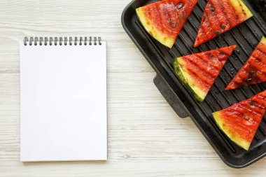 Yukarıdan bir beyaz tahta yüzey üstünde not etmek ile tavada ızgara, ızgara karpuz dilimleri. Düz yatıyordu, genel gider, en iyi görünümü. 