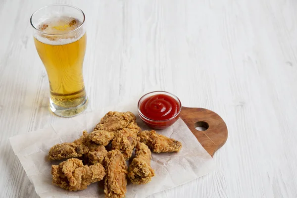 Kırmızı biber soslu tavuk kanadı soğuk bira. Yan görünüm.