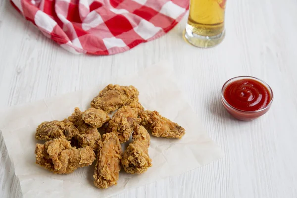 Taze kızarmış tavuk kanadı kırmızı biber sosu, soğuk bira ve peçete. Yan görünüm.