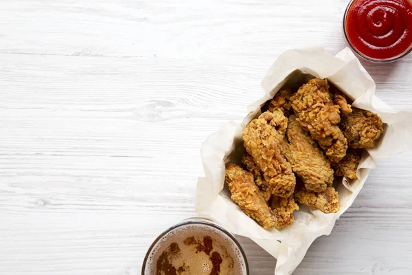 Kırmızı biber sosu, soğuk bira, üstten görünüm ile kızarmış tavuk kanatları. Düz lay, ek yükü. Kopya alanı.