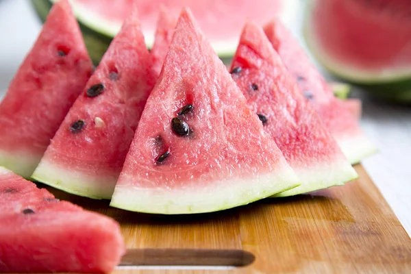 Bambu tahta, yan görünüm üzerinde taze sulu karpuz dilimleri. Yakın çekim. Seçici odak.