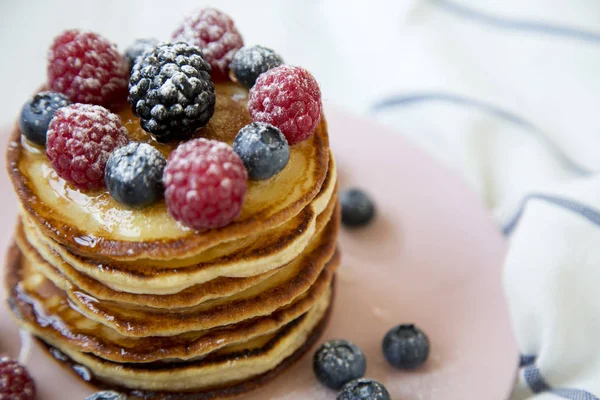 Çeşitli meyveler ve pembe plaka, closeup bal ile Pancakes.