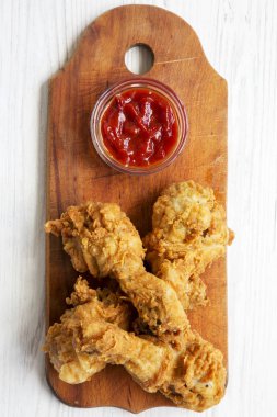 Ahşap masa, üstten görünüm üzerinde soslu kızarmış tavuk sopaları. Tepegöz, yukarıdan lay, düz.