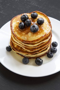 Yaban mersini ve siyah arka plan, yan görünüm üzerinde ballı krep. Yakın çekim. 