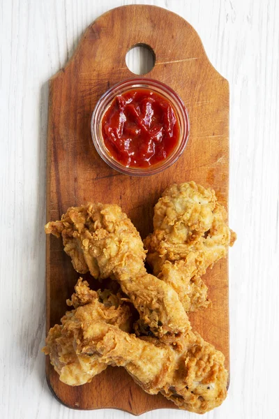 Ahşap masa, üstten görünüm üzerinde soslu kızarmış tavuk sopaları. Tepegöz, yukarıdan lay, düz.