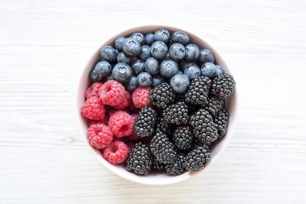 Pembe kase taze çilek: böğürtlen, ahududu, yaban mersini, üstten görünüm. Yaz meyve. Yukarıda, ek yükü. Portre.