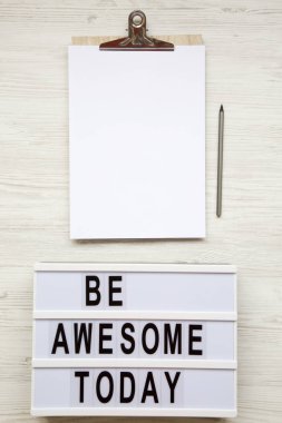 Uzay noticepad, kalem ve 'bugün harika olacak' kelime lightbox ile beyaz ahşap arka plan üzerinde üstten görünüm iş. Yukarıdan, düz-lay, tepegöz. 
