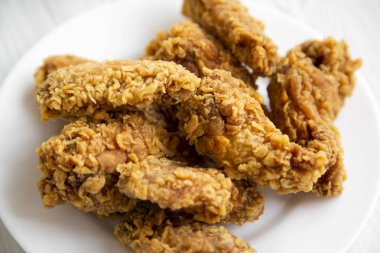 Tavuk kanadı bir tabakta yuvarlak beyaz, portre.