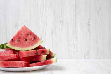 Kopya alanı, closeup ile yuvarlak beyaz tabakta sulu karpuz birçok dilim. Yan görünüm. 
