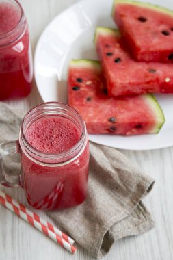 Cam kavanoz karpuz güler yüzlü beyaz ahşap zemin, yüksek açı üzerinde.