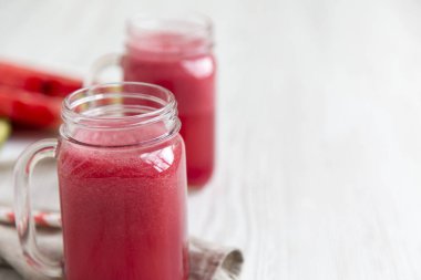 Cam kavanoz karpuz güler yüzlü. Beyaz ahşap arka plan. Yan görünümü. Kopya alanı.