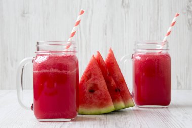 Beyaz ahşap zemin, yan görünüm üzerinde cam kavanozlara karpuz güler yüzlü. 