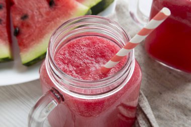 Cam kavanoz karpuz güler yüzlü bir beyaz tahta masada yakın çekim.
