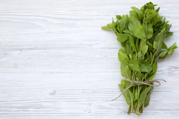 Üstten görünüm, Beyaz ahşap zemin üzerinde taze nane. Kopya alanı, metin alanı.