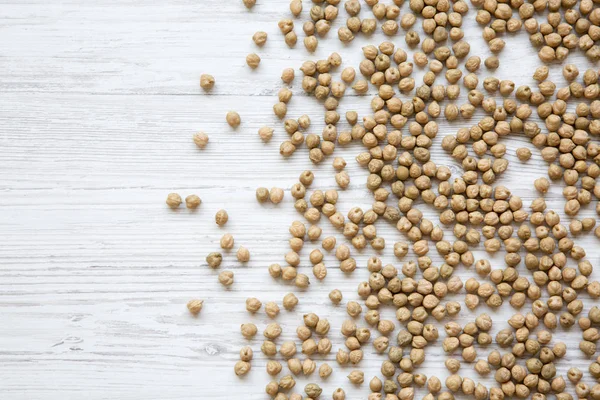 Yukarıdan bir beyaz tahta masada nohut kurumuş. Metin için yer.