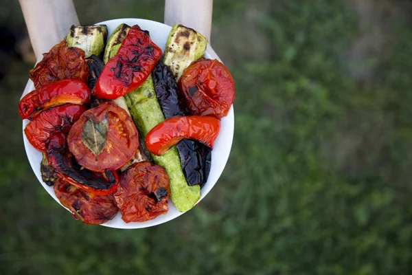 Eller tabak ızgara mevsimlik sebzeler, üstten görünüm tutun. Yukarıdan. Kopya alanı.