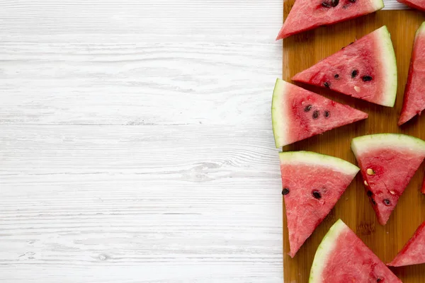 Beyaz ahşap bir masa üstten görünüm Bambu tahta üzerinde karpuz dilimli. Düz lay, ek yükü. Kopya alanı.