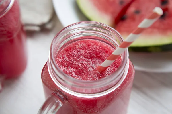 Karpuz yüzlü beyaz ahşap arka planda, düşük açılı. Portre.