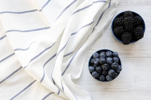 Tam mavi kase çilek Beyaz ahşap yüzey, en iyi görünüm üzerinde. Yaz meyve. Yukarıdan, tepegöz, düz yatıyordu.