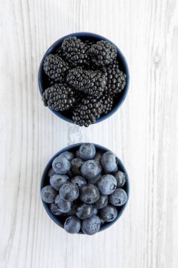 Beyaz ahşap bir masa üstten görünüm üzerinde kase çilek. Yaz meyve. Yukarıdan, tepegöz, düz yatıyordu.