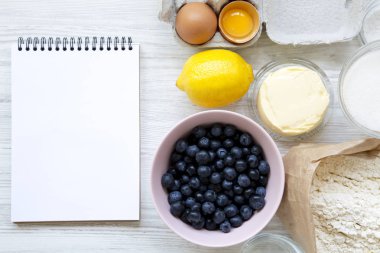 Düz kek, krepteki Not defteri ile yemek pişirmek için ham maddeler yatıyordu. Tepegöz, üstten görünüm. Kopya alanı.