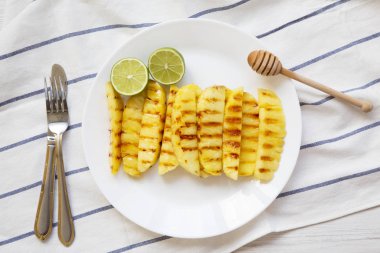 Ananas dilimleri kireç beyaz tabakta, üstten görünüm ile ızgara. Yaz yiyecek. Yukarıdan, tepegöz, düz yatıyordu. 