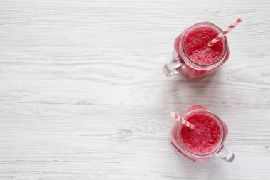 Cam kavanoz karpuz güler yüzlü beyaz ahşap bir masa üstten görünüm üzerinde. Kopya alanı.