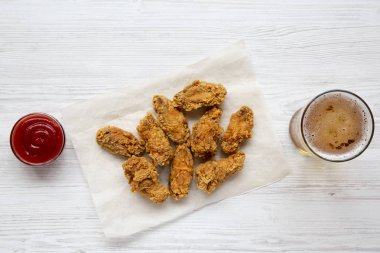 Soslu tavuk kanatları, Beyaz ahşap zemin, üstten görünüm üzerinde soğuk bira. Düz yatıyordu, ek yükü. 