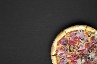 Dan pizza siyah tablo üzerinde yukarıda, taze pişmiş. Düz yatıyordu, genel gider, en iyi görünüm. Boş yer.