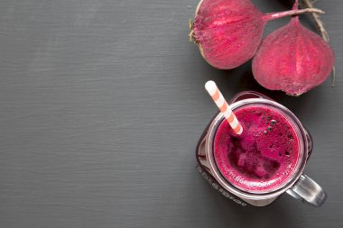 Pancar güler yüzlü siyah arka plan üzerinde cam kavanoz kupa, yukarıdan görüntülemek. Düz lay, ek yükü. Portre. Kopya alanı.