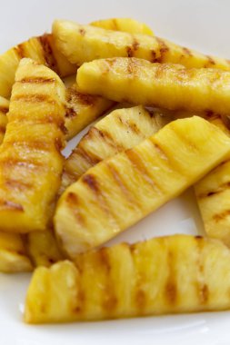 Beyaz tabakta, closeup ızgara ananas dilimleri. Yaz yiyecek. Yan görünüm.
