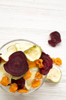 Kase sebze cips Beyaz ahşap zemin üzerinde tam, yukarıdan görüntülemek. 