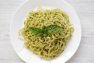Beyaz ahşap zemin üzerine pesto soslu makarna spagetti tabak. Ana sayfa görünümü, yukarıdan, ek yükü.