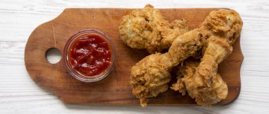 Ahşap masa, üstten görünüm üzerinde soslu kızarmış tavuk sopaları. Tepegöz, yukarıdan lay, düz.