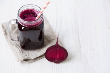 Cam kavanoz pancar güler yüzlü beyaz ahşap masa, yüksek açı üzerinde. Kopya alanı.