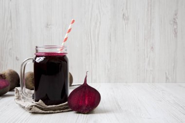 Cam kavanoz pancar güler yüzlü beyaz ahşap arka planda, yan görünüm. Kopya alanı.