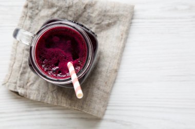 Cam kavanoz pancar güler yüzlü, üstten görünüm. Beyaz ahşap arka plan. Yukarıdan, tepegöz, düz yatıyordu. Kopya alanı.