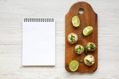 Mantar ve tavuk püresi, kireç ve beyaz ahşap bir masa üstten görünüm üstünde not etmek. Düz lay, ek yükü. Metin için yer.