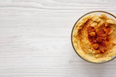 Leblebi, kırmızı biber, zeytin yağı Beyaz ahşap zemin, üstten görünüm üzerinde humus kase. Kopya alanı.