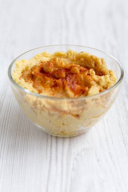 Humus kase üzerinde beyaz ahşap bir masa düşük açılı leblebi, kırmızı biber, zeytin yağı ile. Portre.