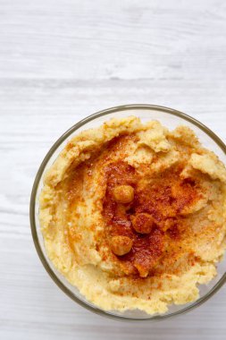 Kase bir beyaz tahta yüzeyi, havai görünümü baharat humus. Portre. 