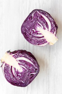 Üstten görünüm Beyaz ahşap zemin üzerinde kırmızı lahana iki yarısı. Yukarıdan, tepegöz, düz yatıyordu.