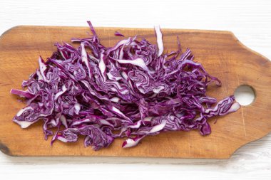 Kesme tahtası, closeup üzerine doğranmış kırmızı lahana. Görünümü, tepegöz, yukarıdan top.