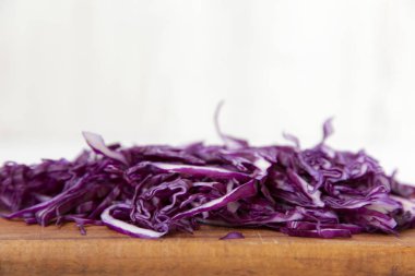 Doğranmış kırmızı lahana closeup rustik ahşap gemide. Yan görünümü. Seçici odak.