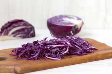 Kesme tahtası, closeup üzerine doğranmış kırmızı lahana. Yan görünüm. 