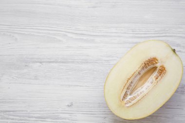 Beyaz ahşap arka plan, üstten görünüm kavun yarısı. Yukarıda, ek yükü. Kopya alanı.