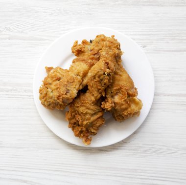 Kızarmış tavuk budu üzerinde beyaz bir levha, üstten görünüm yuvarlak. Yukarıdan, tepegöz, düz yatıyordu.