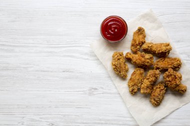 Beyaz ahşap yüzey, en iyi görünüm ketçap ile kızarmış tavuk kanatları. Yukarıda, ek yükü. Kopya alanı.