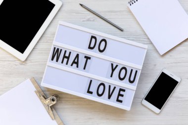 Çalışma alanı ile Pano, kalem, Not defteri, telefon, tablet ve metin ile modern yönetim kurulu 'Do ne aşk' Beyaz ahşap arka plan üzerinde. Yukarıdan, ek yükü yat. 