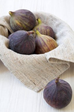 Beyaz ahşap arka plan, yan görünüm üzerinde bir kapta taze incir.